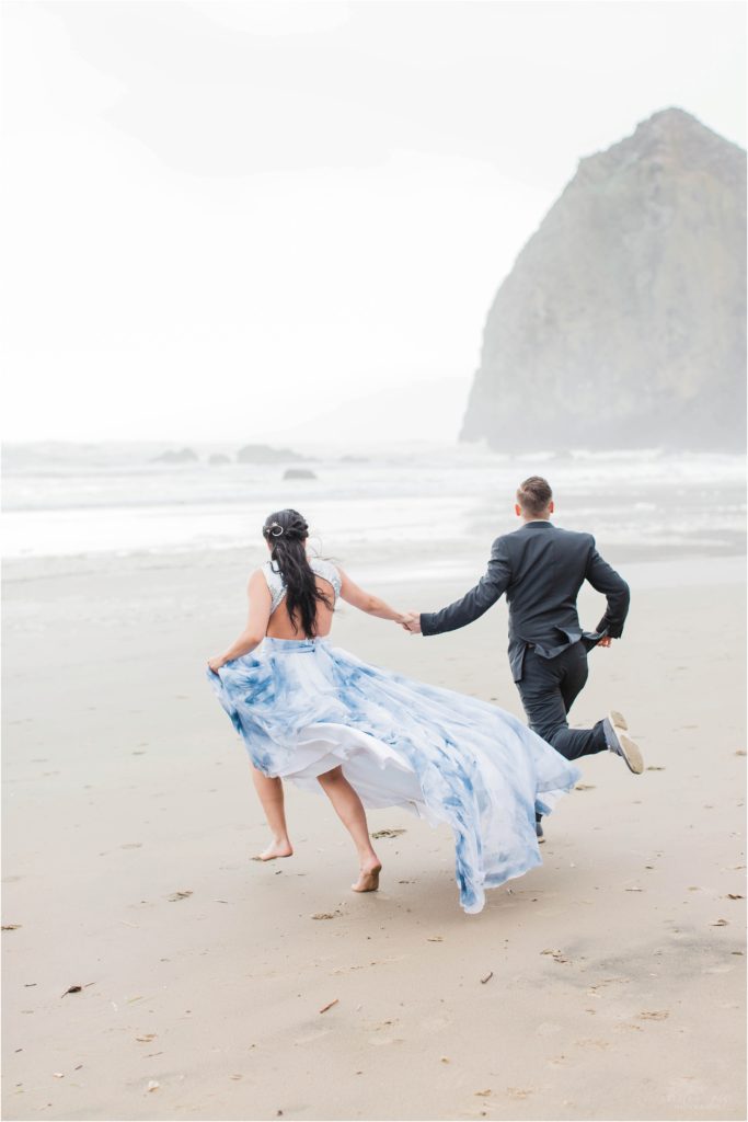 Bride and groom running on Cannon Beach after elopement