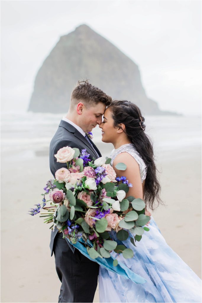 Couple standing on Cannon Beach in Oregon for elopement