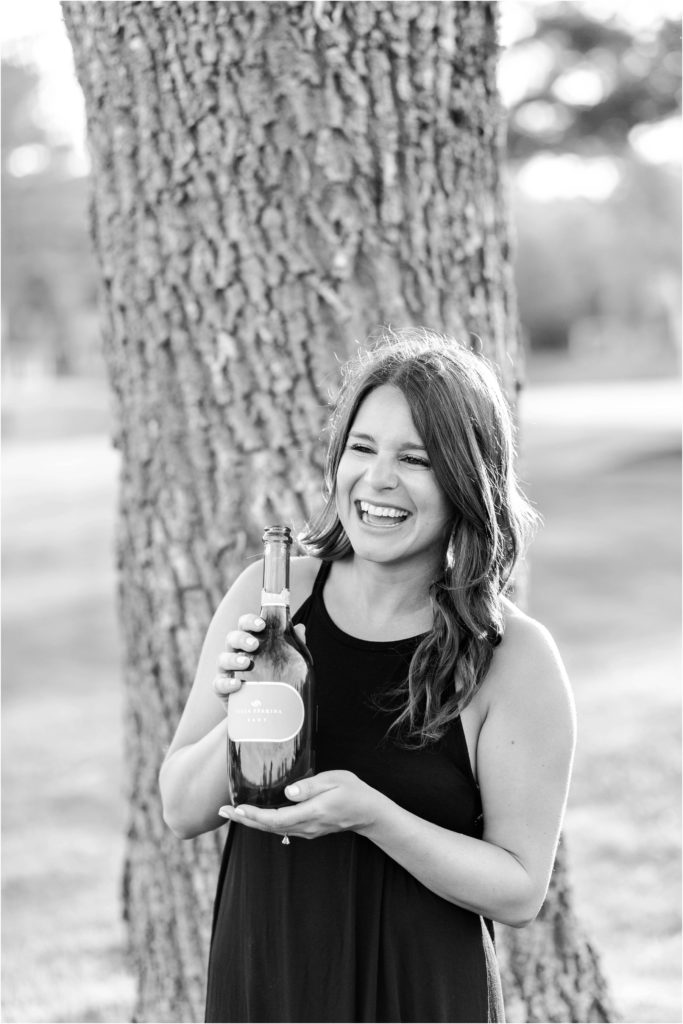 black and white photo of woman holding champagne bottle