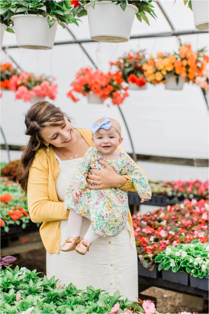 mom holding baby girl in flowered dress