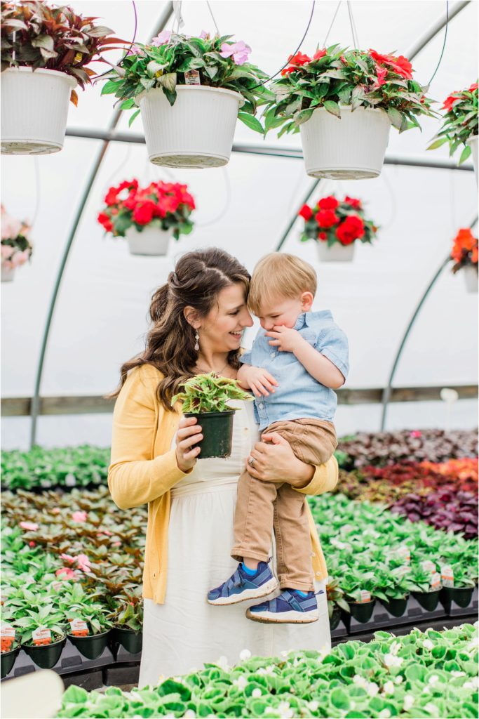 mom holding little boy with plant