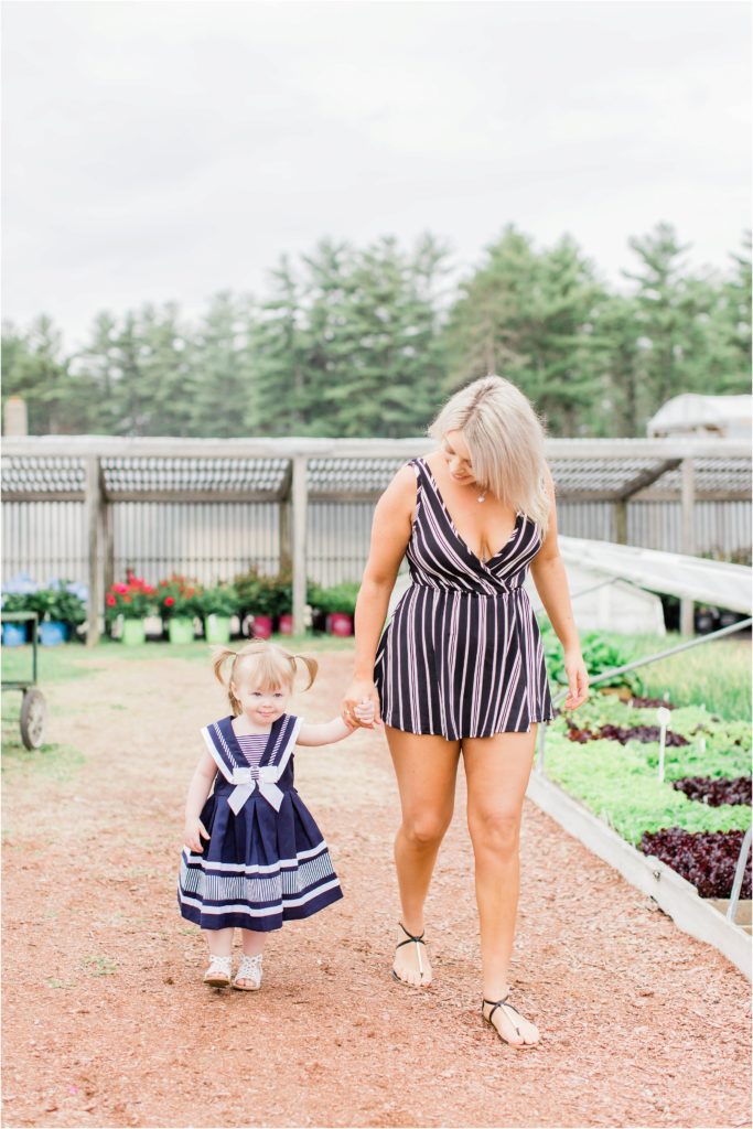 little girl walking with mom in plant nursery
