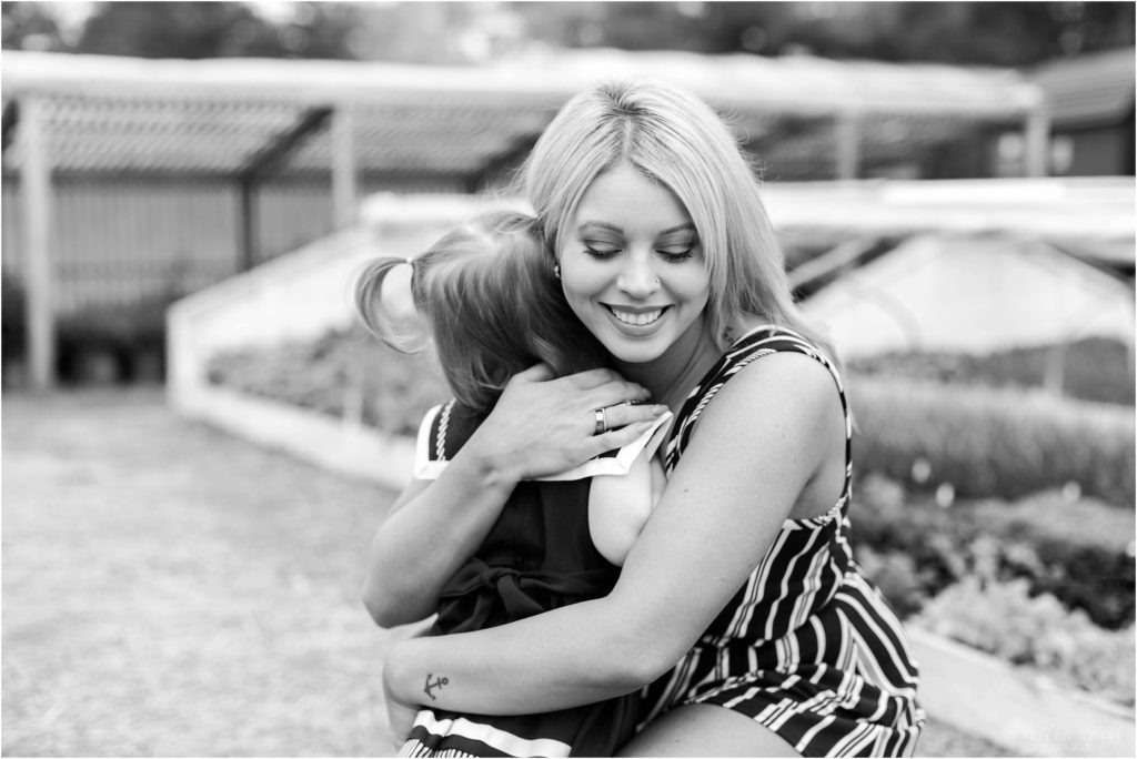 black and white photo of mom hugging little girl