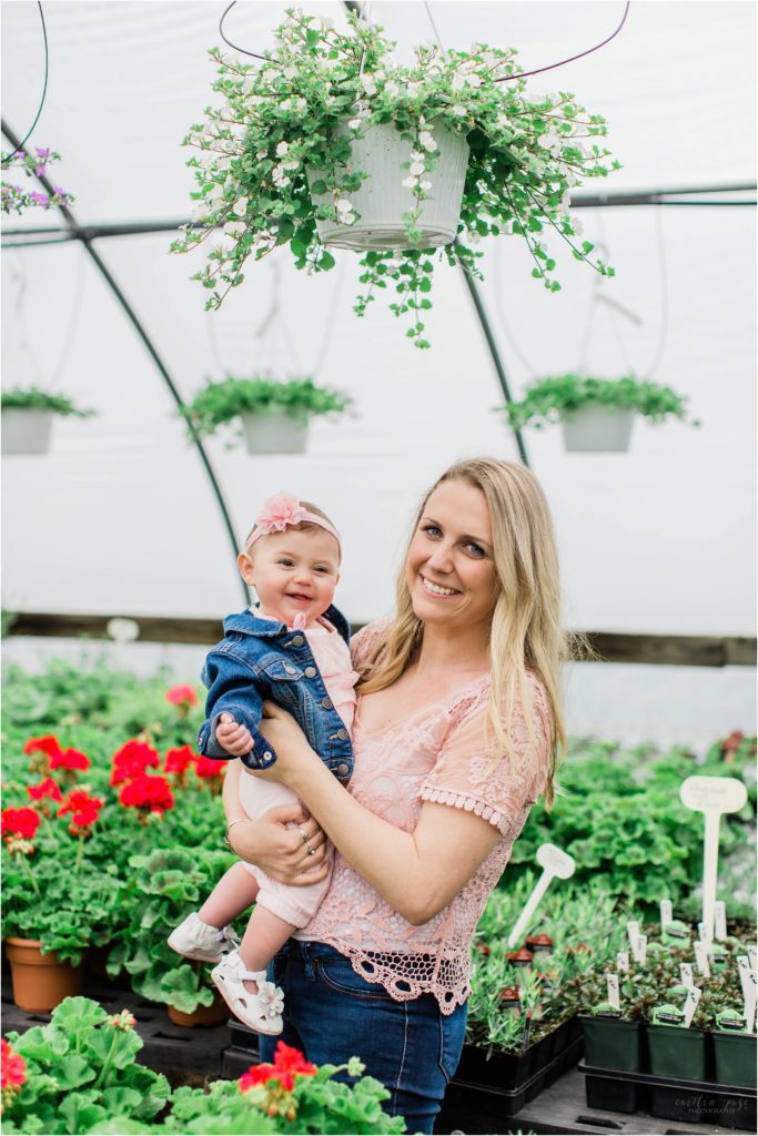 woman and baby smiling in greenhouse