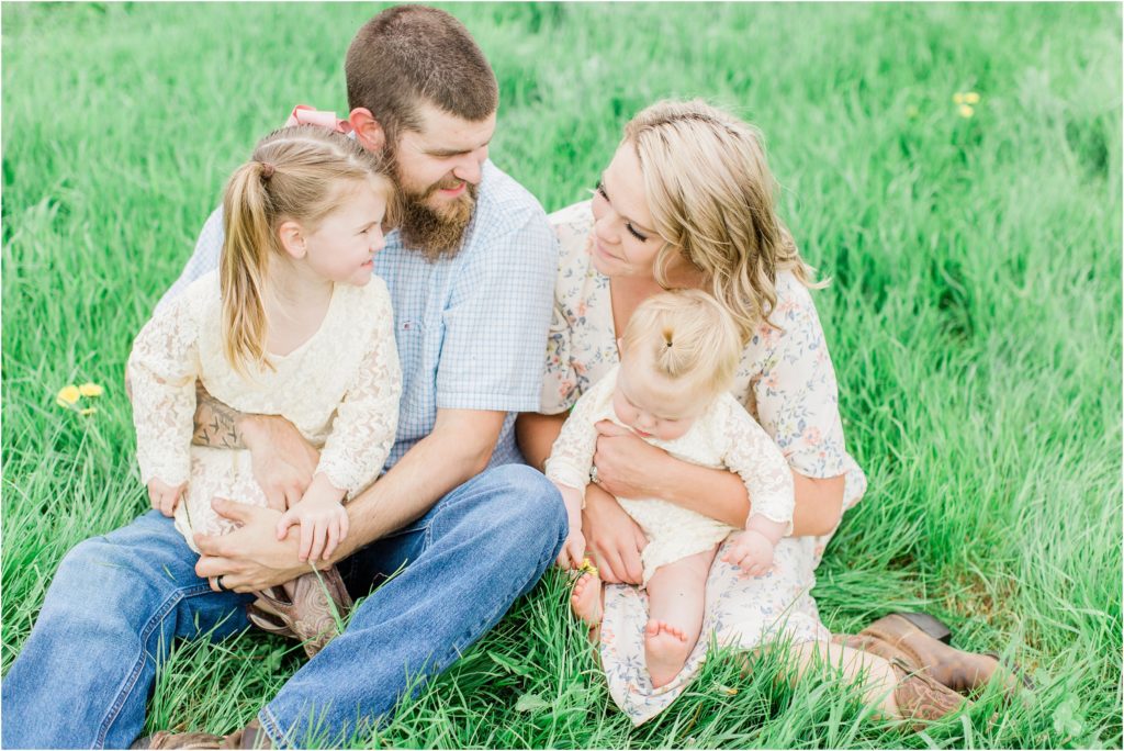 family sitting on the ground in a field