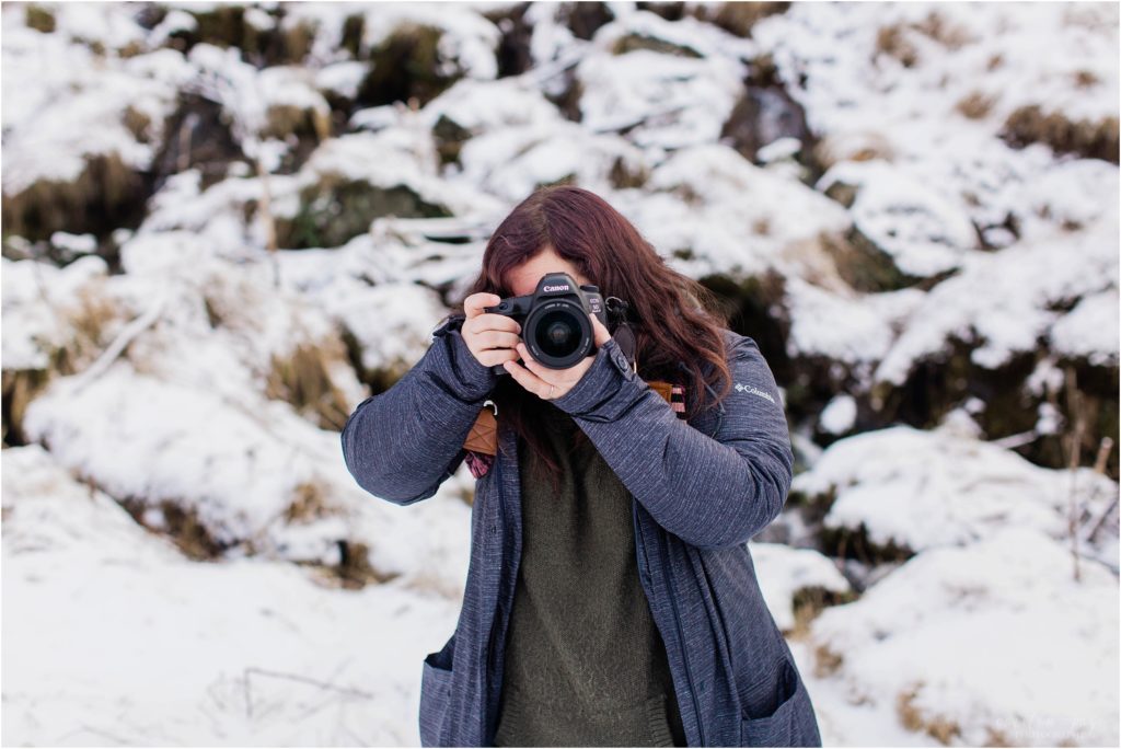 girl taking photo in iceland during the winter