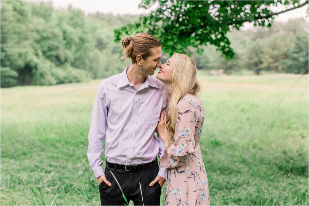 Man and woman kissing under a tree