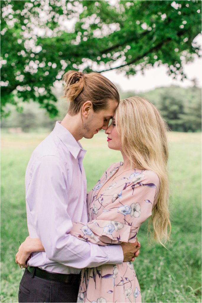 Man and woman standing forehead to forehead in field