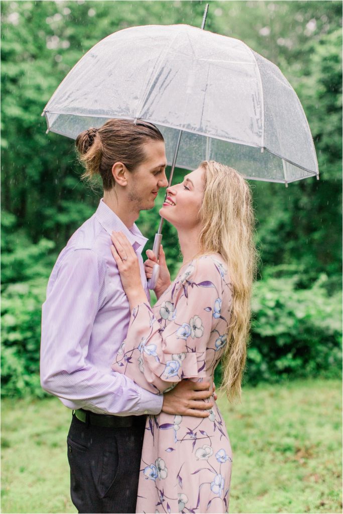 Man and woman snuggled under umbrella