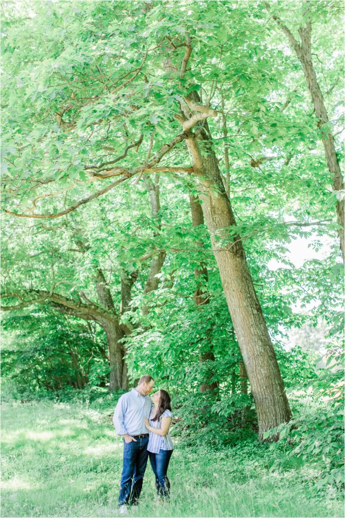man and woman kissing under large tree
