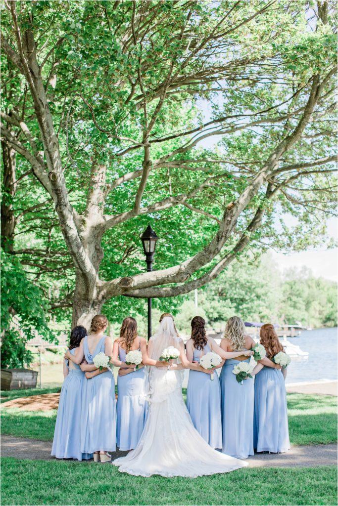 bridesmaids standing together in front of lake