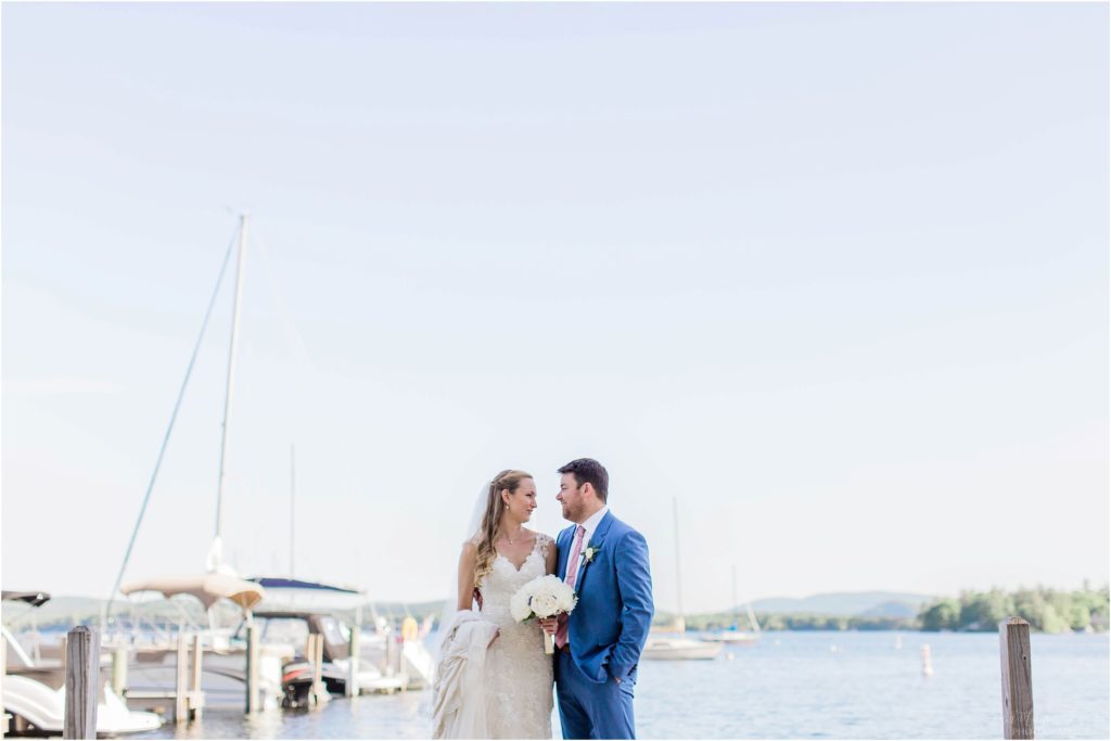 bride and groom standing on dock lake winnipesaukee
