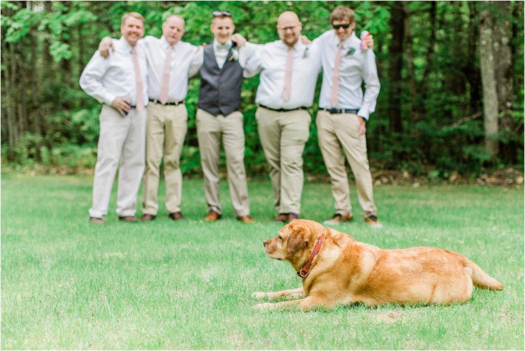 dog laying in front of groomsmen