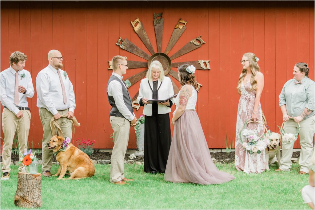 wedding ceremony in front of red barn