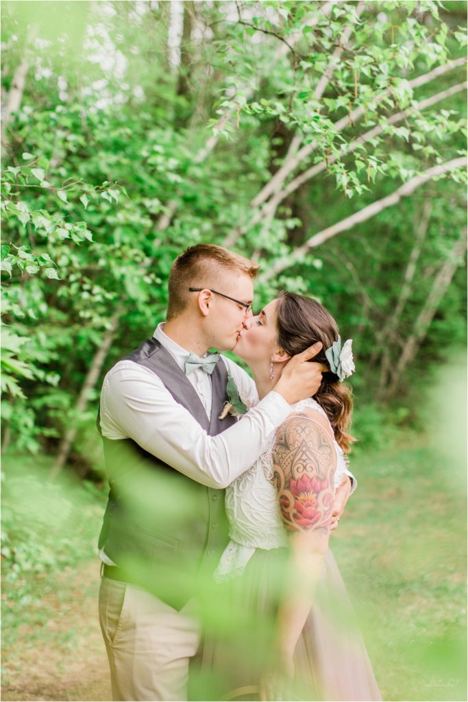 bride and groom kissing in leaves