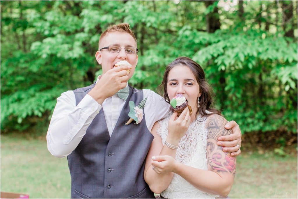 bride and groom eating cupcakes