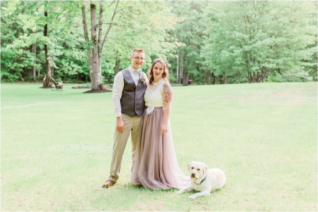 bride and groom portrait with dog laying on skirt