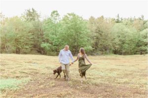 couple walking with dog in field
