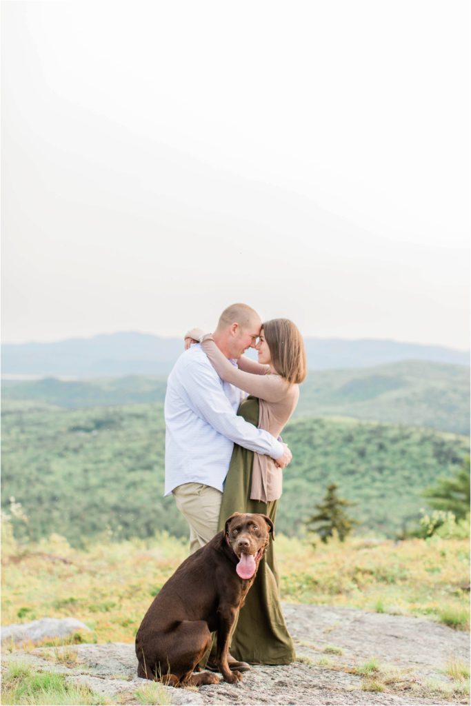 couple standing on mountaintop with dog