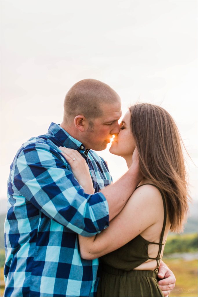 couple kissing at sunset with sun flare