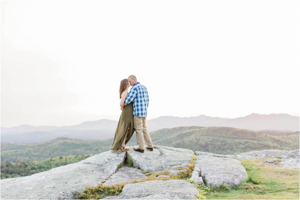 couple kissing on top of mountain