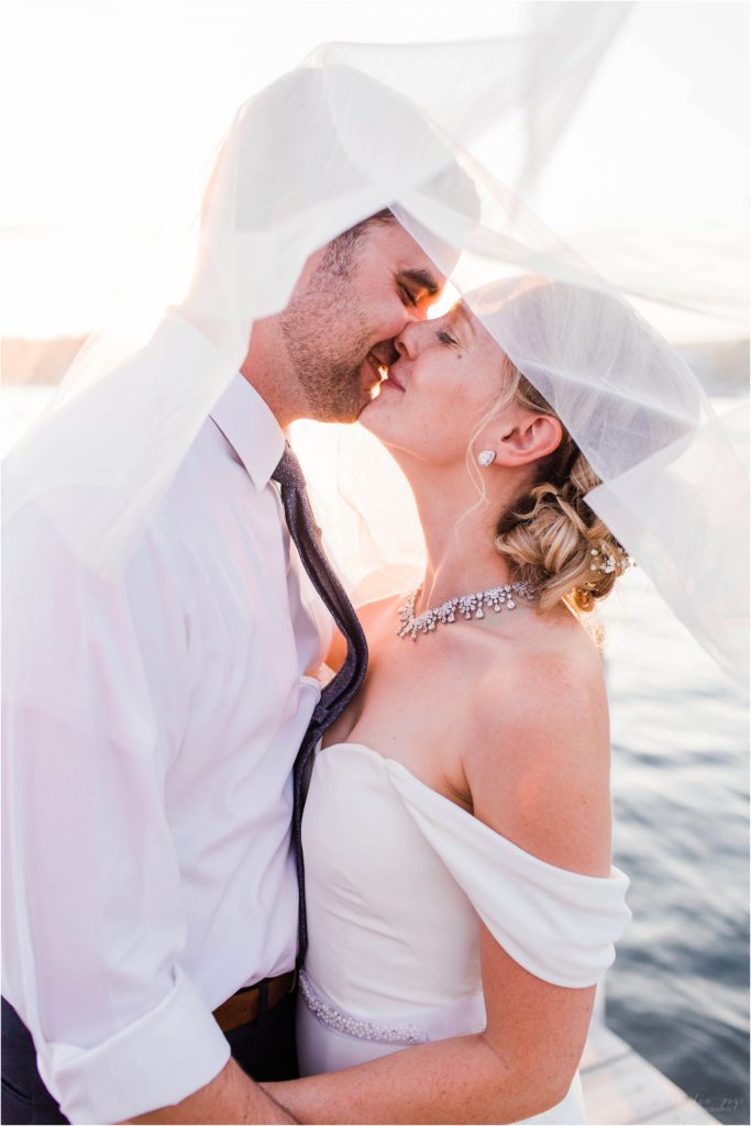 Couple almost kissing under veil at sunset on Brewster Docks Wolfeboro New Hampshire