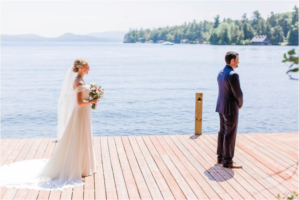 Bride and groom at first look standing on a dock