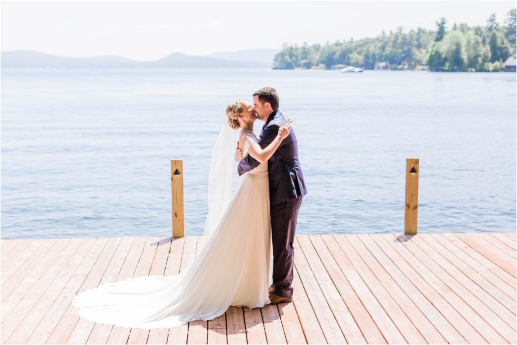 Bride and groom kissing at first look on a dock