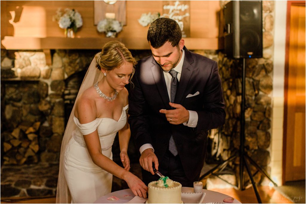 Bride and groom cutting wedding cake at Brewster Boathouse wedding Wolfeboro