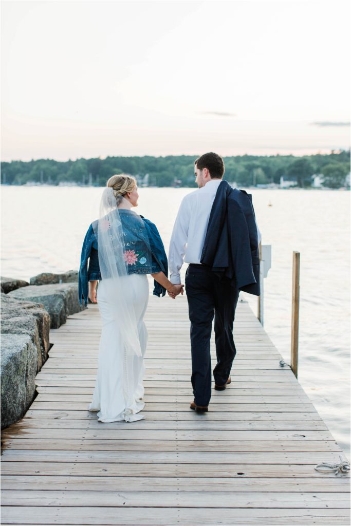 Bride and groom walking down docks at Brewster Boathouse Wolfeboro New Hampshire
