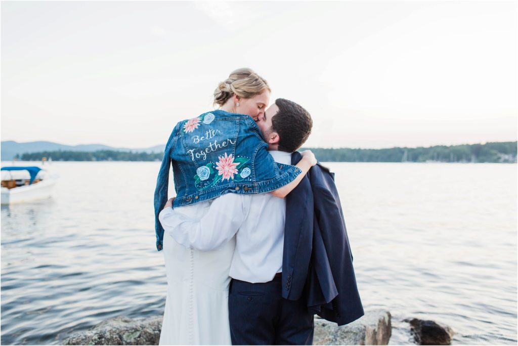 Bride and groom kissing on dock at Brewster Boathouse Wolfeboro