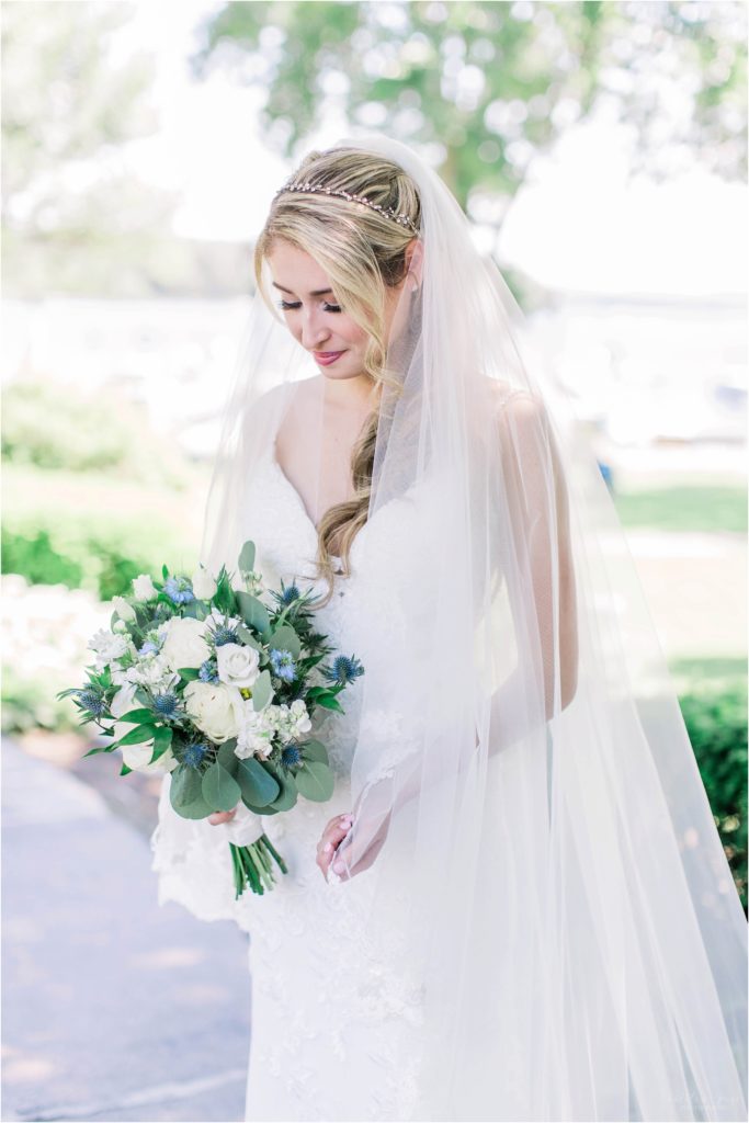 bride with cathedral length veil and white and blue bouquet