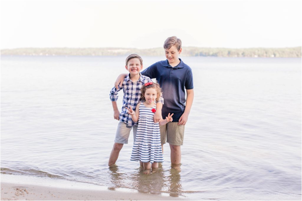 Three kids standing in the lake