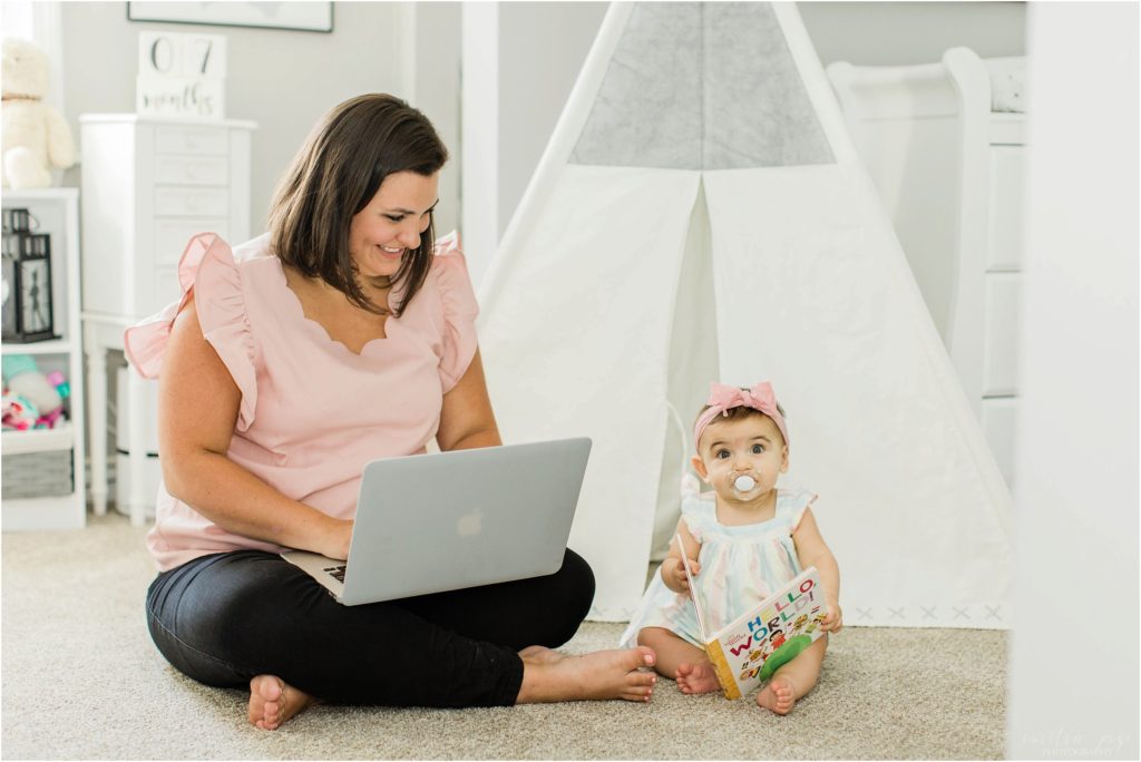 Mom working on computer with little girl