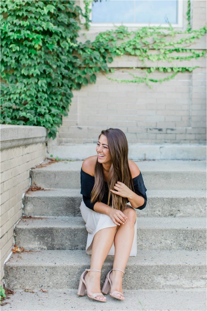 Woman laughing sitting on steps in off the shoulder black shirt