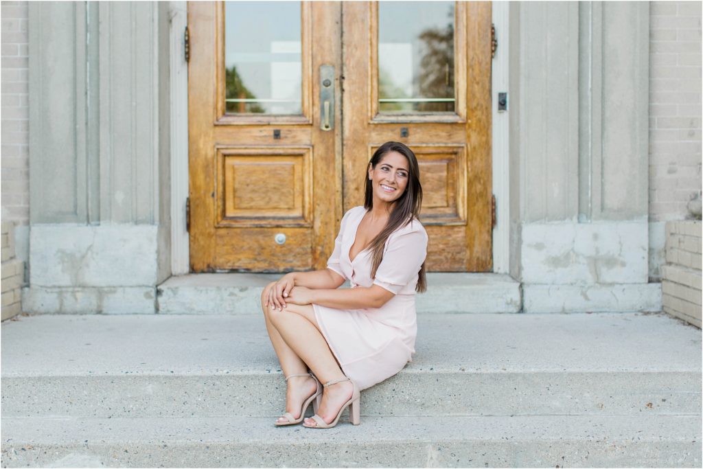 Woman in pink dress sitting on steps of Brewster Academy