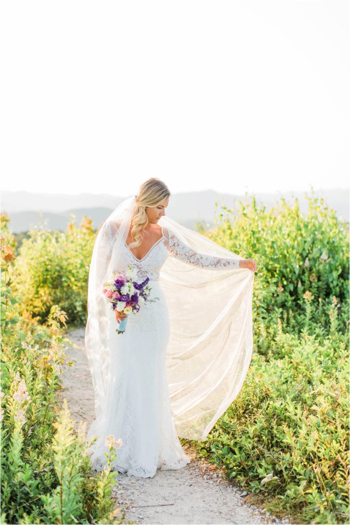 Bride standing on top of Foss Mountain with long veil on