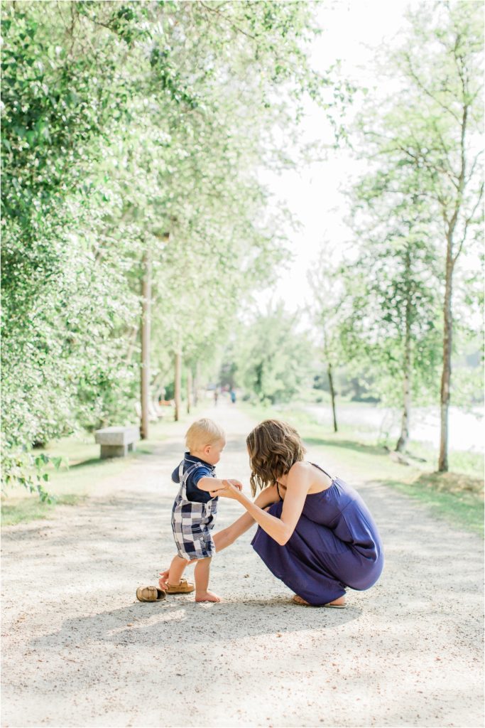Mom in blue dress helping baby boy with his shoe