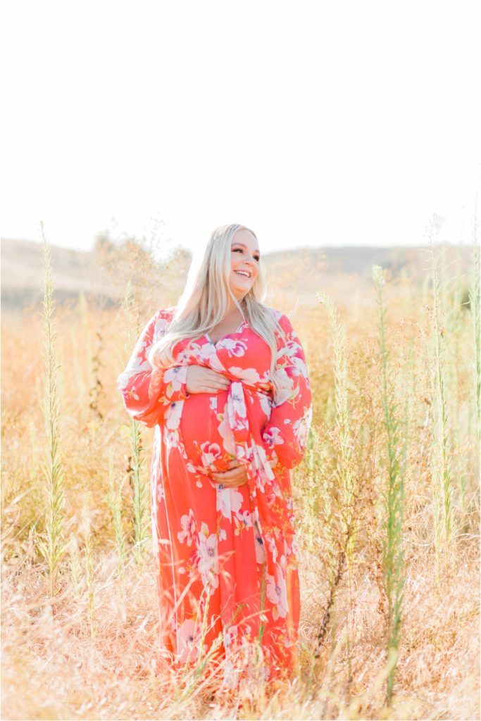 Pregnant woman laughing in field