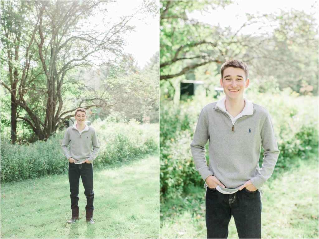 senior boy standing under tree in field