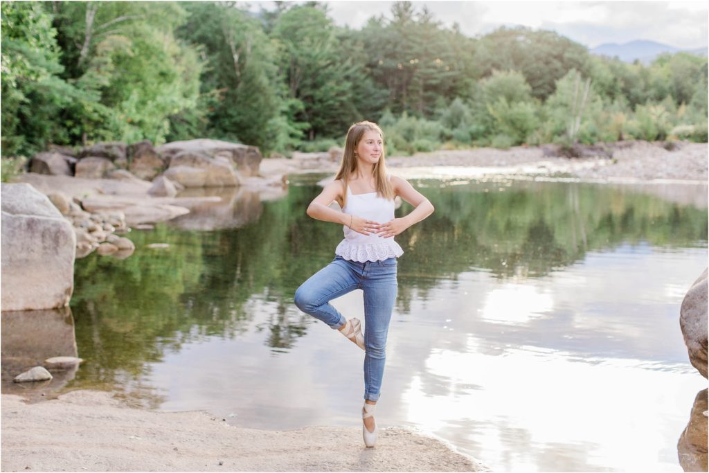 senior girl on pointe on rock next to river
