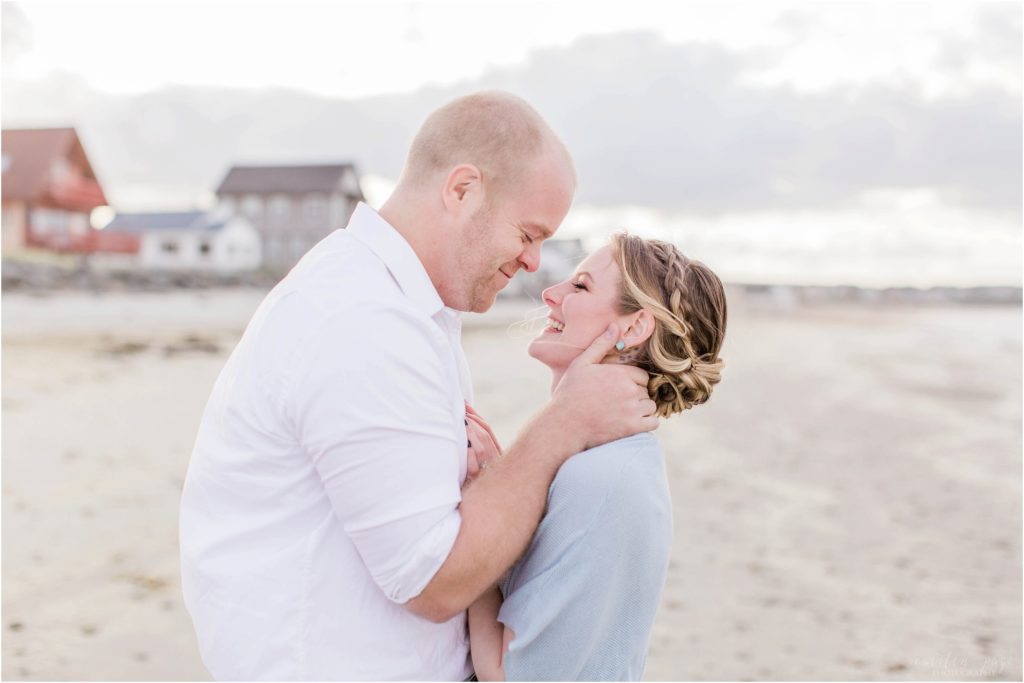 man holding womans face on beach at sunset