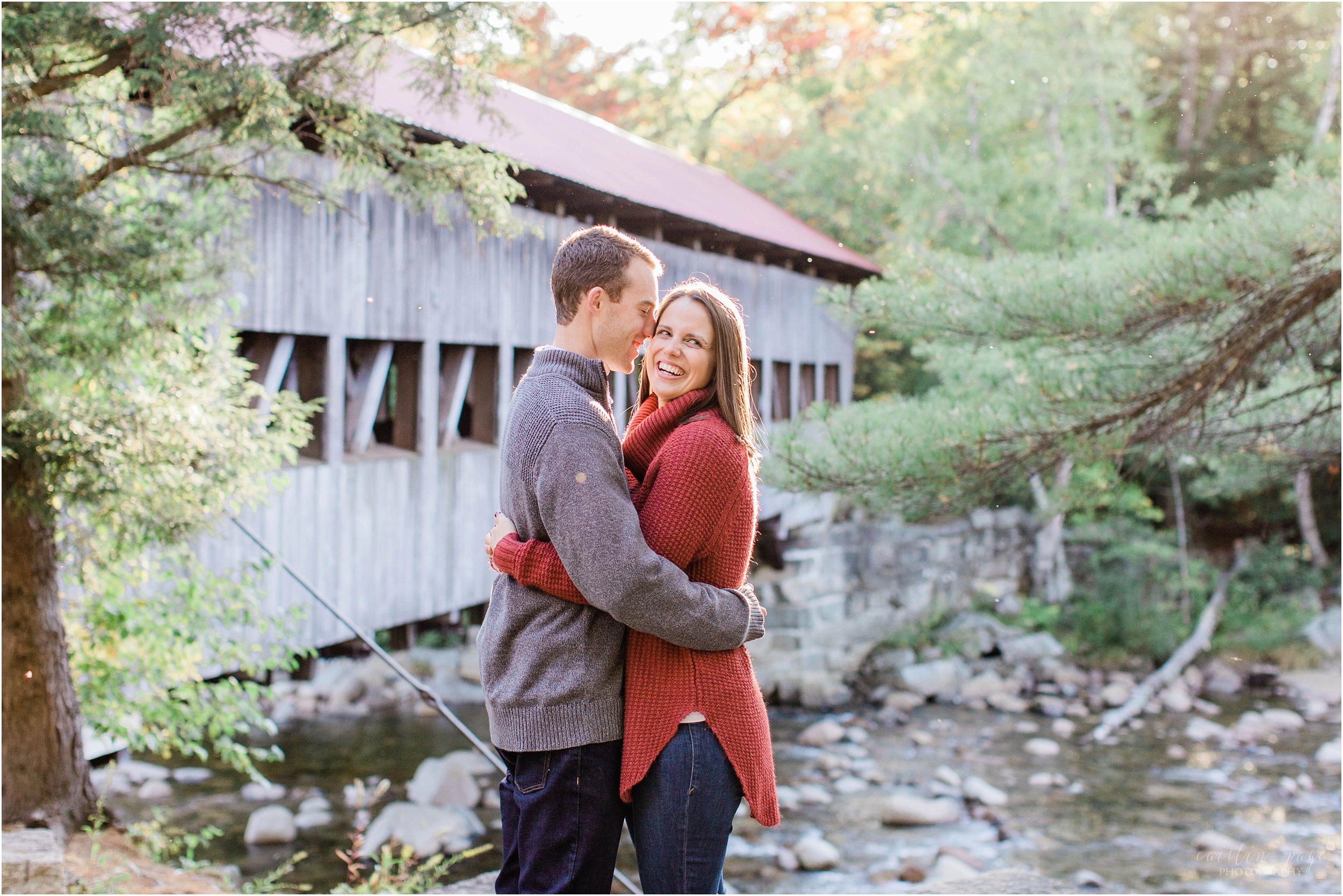 couple standing in front of covered bridge at sunset