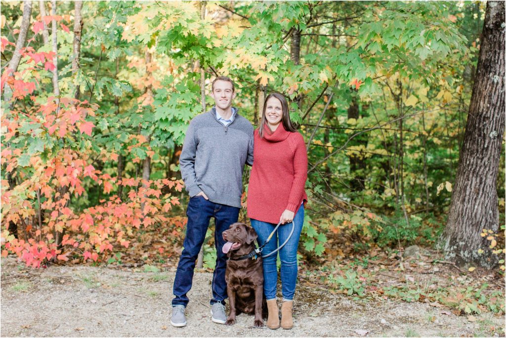 couple standing with chocolate lab