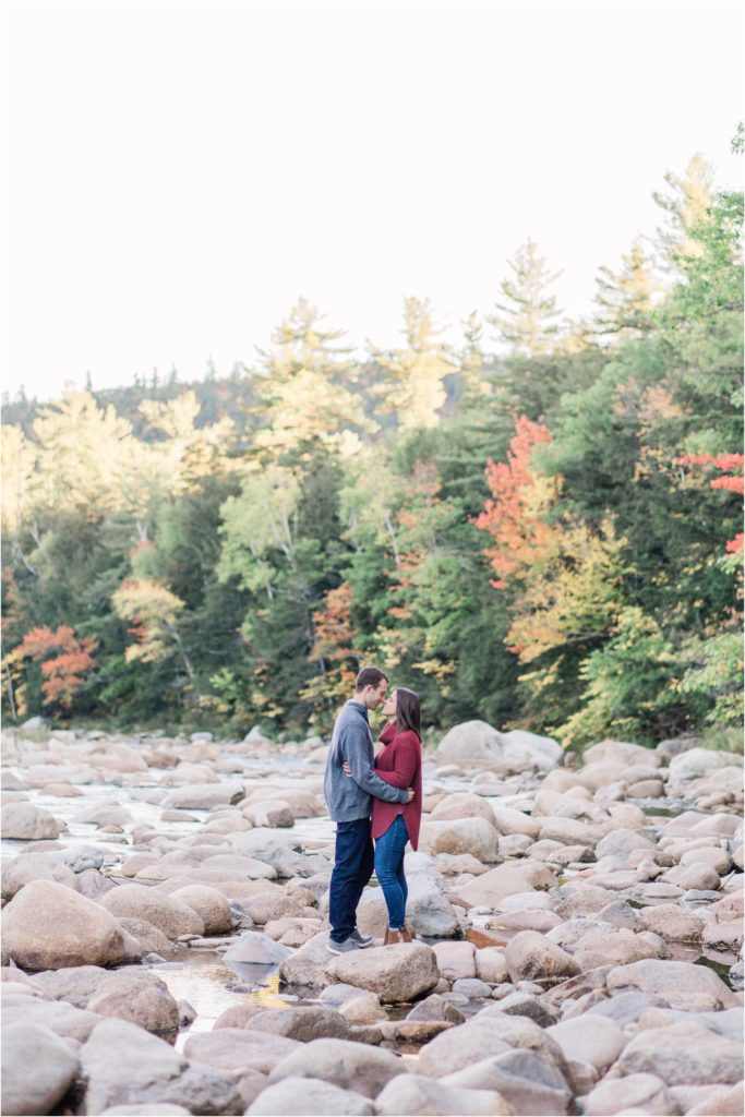 couple standing on river rocks