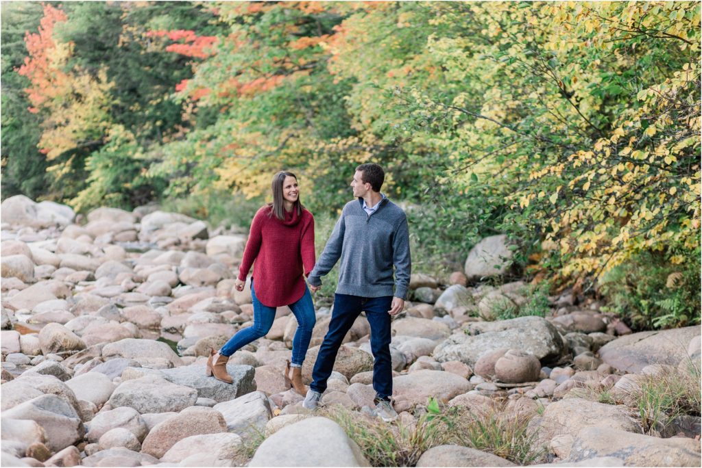 couple waking on river rocks