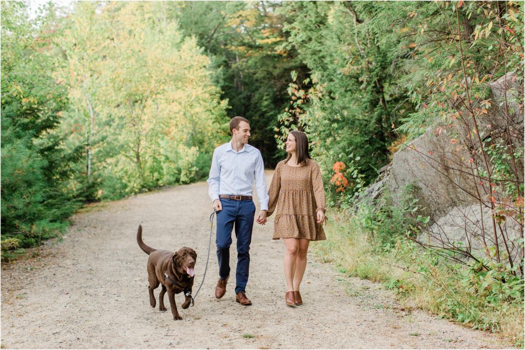 man and woman walking with chocolate lab