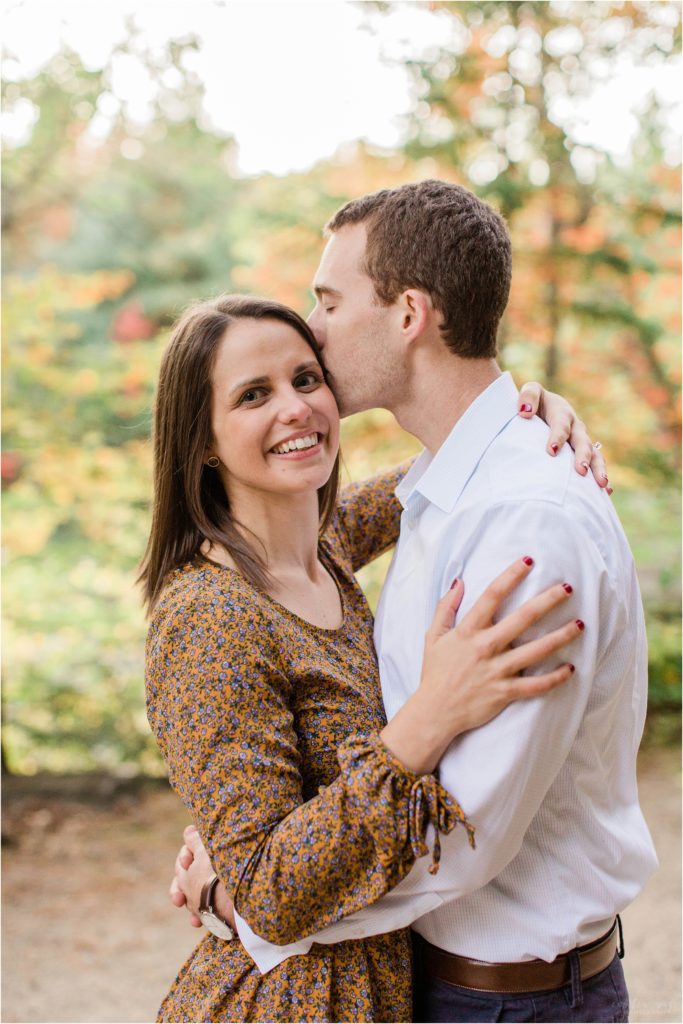 man with his arms around woman engagement photos