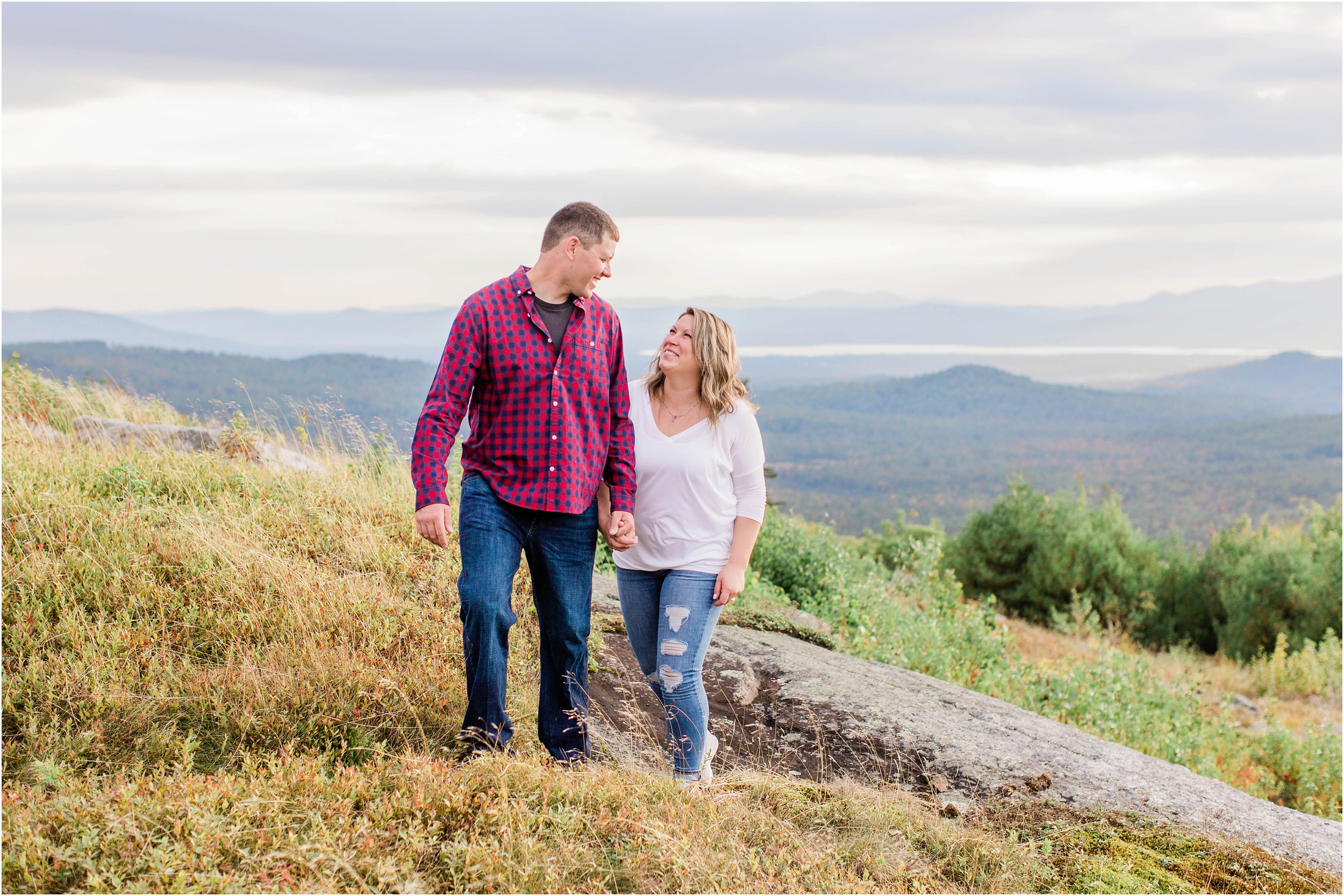 man and woman walking together on top of mountain