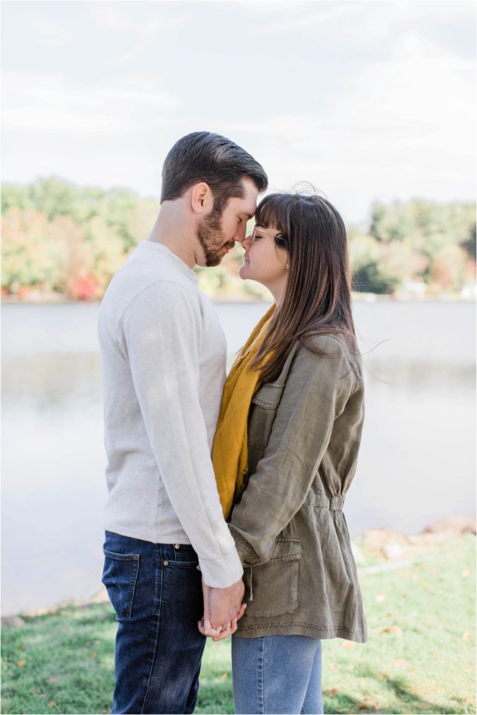 man and woman standing nose to nose in front of water
